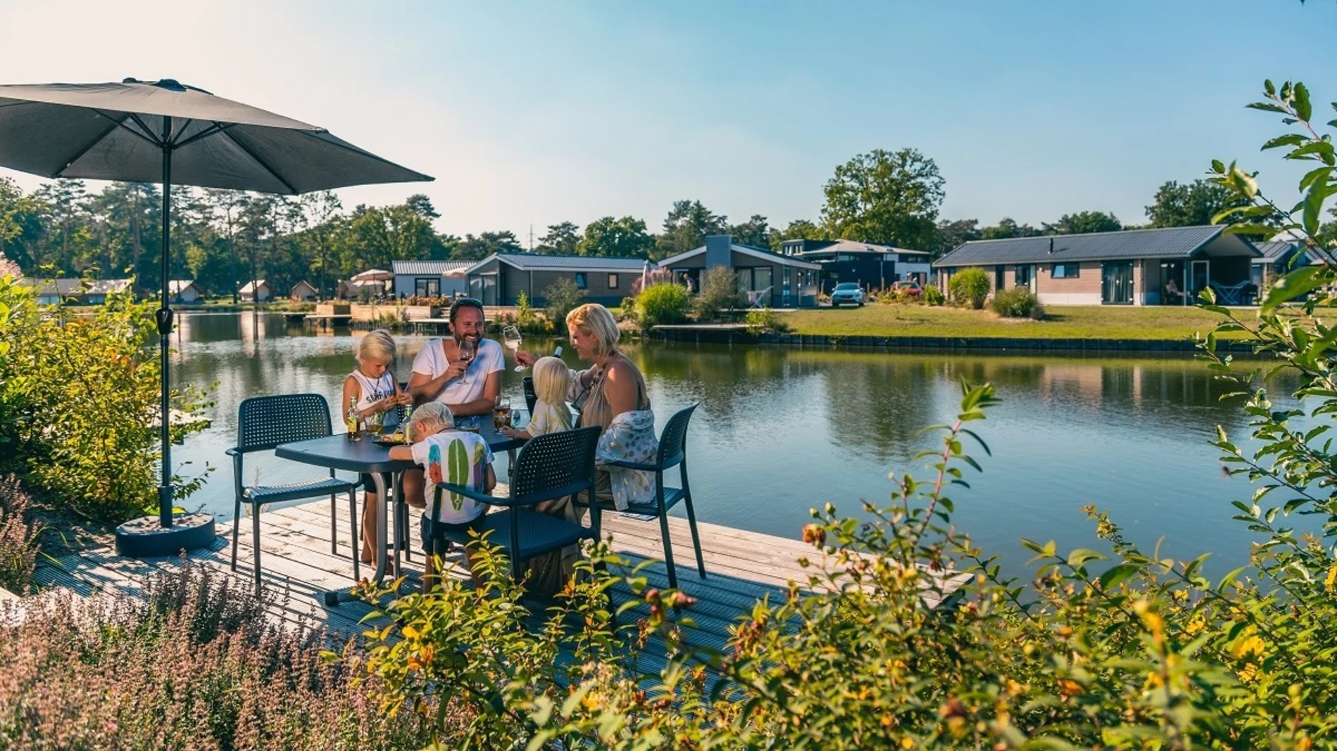 EuroParcs_Zilverstrand_Family_enjoying_the_sun_in_their_holiday_home_at_the_water